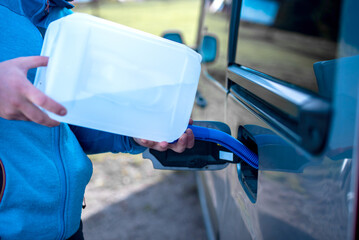 Pouring adblue to the car. Male driver adding Diesel exhaust fluid to his car.