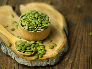 raw pumpkin seeds on old wooden background ,copy space