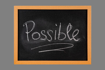 The word Possible handwritten with white chalk on blackboard with wooden frame, isolated on middle gray background