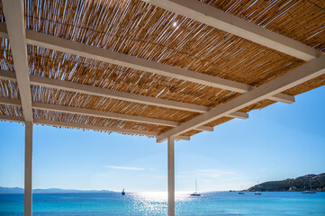 Dachkonstruktion aus Bambusmatten im mediterranen Stil vor einem wunderschönen Strand