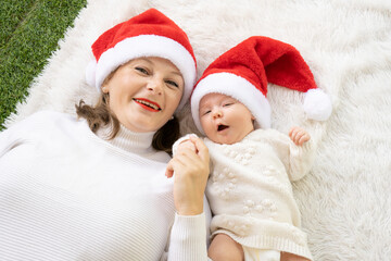 Our first christmas together - happy mother and baby girl in santa hats