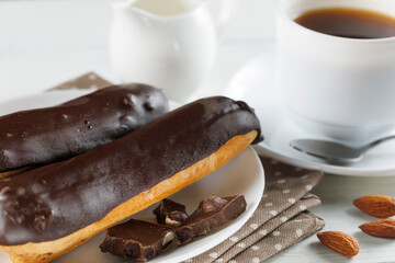 Chocolate eclairs in a white plate close-up.