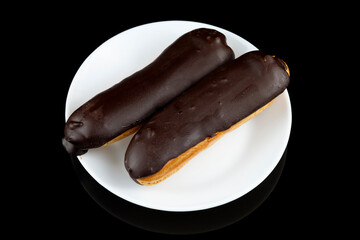 Chocolate eclairs in a white plate close-up.