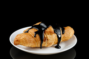 Chocolate poured on croissant close-up. Chocolate with a croissant on a plate.
