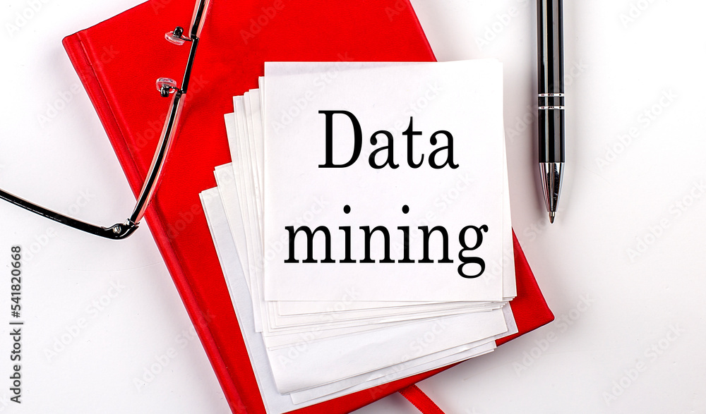 Aufkleber data mining text on sticker on red notebook with pen and glasses