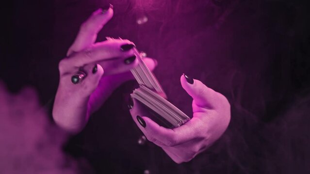 Woman witch shuffles tarot deck, preparation for consultation on predicting future destiny. Fortune teller, medium, divination cards.