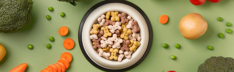 Dry dog vegan vegetarian food concept. Raw vegetables and green near bowl with pet feed