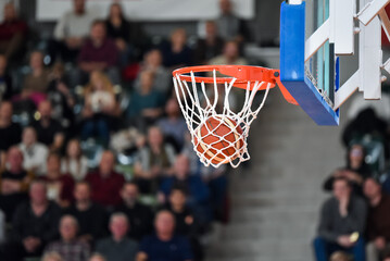 The ball falling into the basket during a basketball game