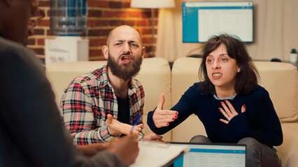 Displeased people complaining about marriage conflict and relationship problems, having argument in office at therapy session. Couple aatendign counseling meeting with therapist.