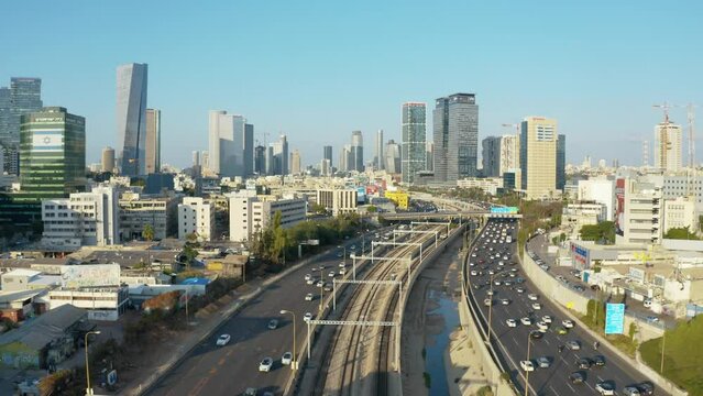 Aerial flight toward tel aviv and ramat gan skyline with urban skyscrapers and cars driving on the highway, Israel