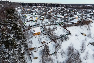 Summer cottages covered with white snow in winter, aerial view