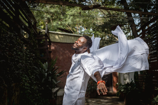 a black man moving freely in a garden 