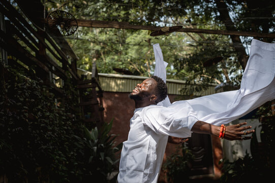 a black man moving freely in a garden 