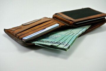 JOHOR, MALAYSIA -MAY 02, 2016: Several pieces of 50 Malaysian Ringgit and a old wallet