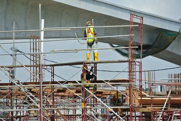 PERAK, MALAYSIA -APRIL 05, 2016: Construction workers wearing safety harness and installing...