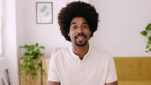 POV - point of view camera of happy young african american man talking to the camera during online video call. Cheerful millennial guy with afro hairstyle making a virtual conference from home. 