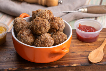 small homemade fried meat meatballs for cold buffet with sauces on wooden board in ceramic time