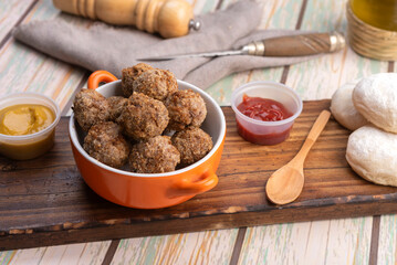 small homemade fried meat meatballs for cold buffet with sauces on wooden board in ceramic time