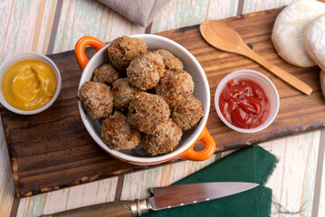 small homemade fried meat meatballs for cold buffet with sauces on wooden board in ceramic time