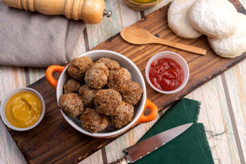 small homemade fried meat meatballs for cold buffet with sauces on wooden board in ceramic time