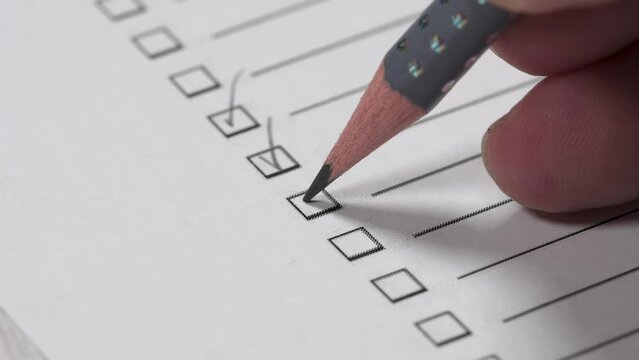 Closeup shot of a male's hand checking boxes on the to-do list