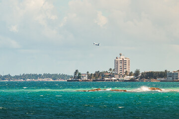 Beautiful condado city beach landscape with airplane flying from puerto rico tropical coast