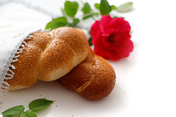 Challah bread covered with a special napkin on white background. Traditional Jewish Shabbat ritual. Shabbat Shalom.