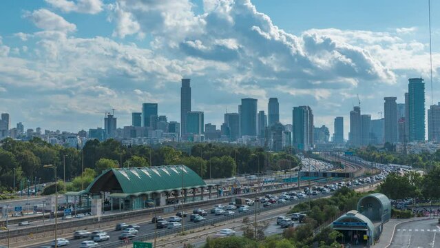 Time lapse of cars driving via ayalon road, in front of the cityscape of ramat gan and Tel Aviv cities with moving blue cloudy skies, Israel