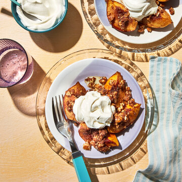 Air fryer peach crumble on a plate with whipped cream