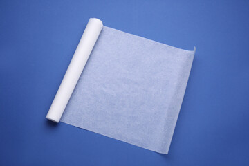 Roll of baking paper on blue background, top view