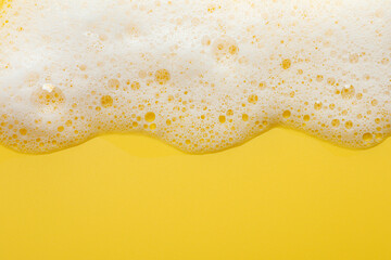 Fluffy soap foam on yellow background, top view. Space for text - obrazy, fototapety, plakaty