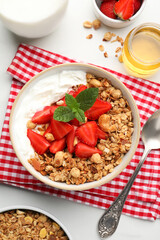 Flat lay composition with tasty granola and ingredients served on white table. Healthy meal