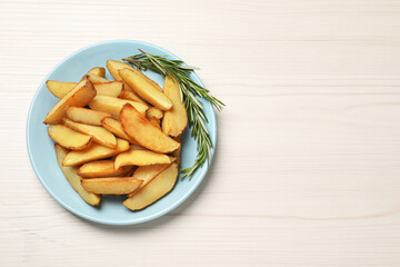 Plate with delicious baked potatoes and rosemary on white wooden table, top view. Space for text
