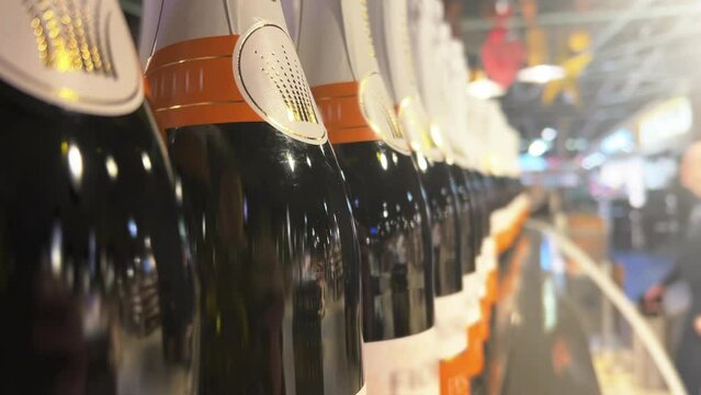 Champagne bottles line up in a liquor store, ABC store, or supermarket. Closeup. Blurred background