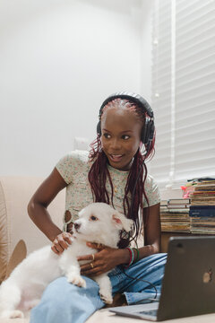 woman with headphones playing with her dog
