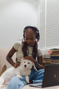 woman with headphones playing with her dog