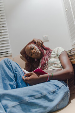 black women reading a book on the sofa