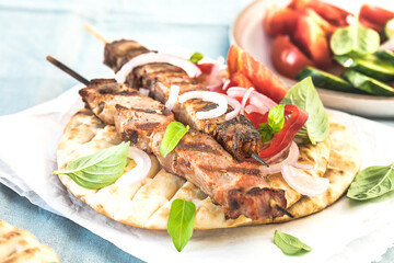 Pork souvlaki, kebabs on skewers with  salad and fresh home made tzatziki
