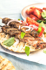 Fototapeta na wymiar Pork souvlaki, kebabs on skewers with salad and fresh home made tzatziki
