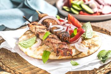 Pork souvlaki, kebabs on skewers with  salad and fresh home made tzatziki