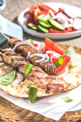 Pork souvlaki, kebabs on skewers with  salad and fresh home made tzatziki