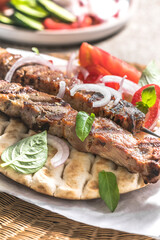 Fototapeta na wymiar Pork souvlaki, kebabs on skewers with salad and fresh home made tzatziki