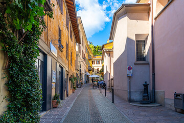 Een kleurrijke straat met winkels en terrasjes in het historische centrum van de stad Menaggio, Italië, aan het meer, aan de oevers van het Comomeer.