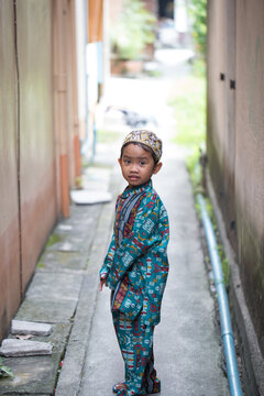 Asian Muslim boy making cute poses in Muslim clothes