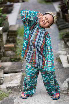 Asian Muslim boy making cute poses in Muslim clothes