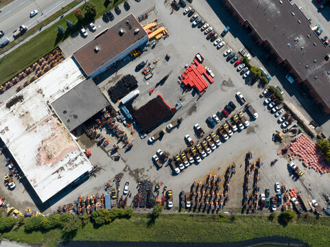 A top-down aerial view above a center with road construction supplies, including traffic cones, signs, machinery and more.