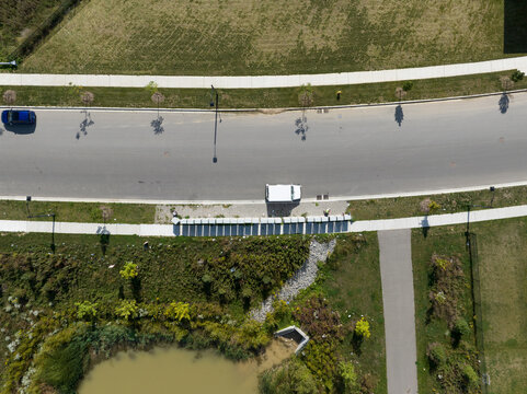 A direct overhead aerial view above a postal van at a row of mailboxes in a residential area.
