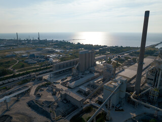 Obraz premium An aerial above a harborfront coal mining and processing facility, seen in the early morning.
