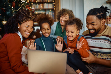 Happy African American extended family congratulating Christmas during video call via laptop from home.