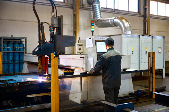 Engineer controls operation of portal plasma cutting machine